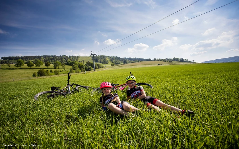Kinder mit Bikes im Gras an der Talstation der Ettelsberg-Seilbahn 