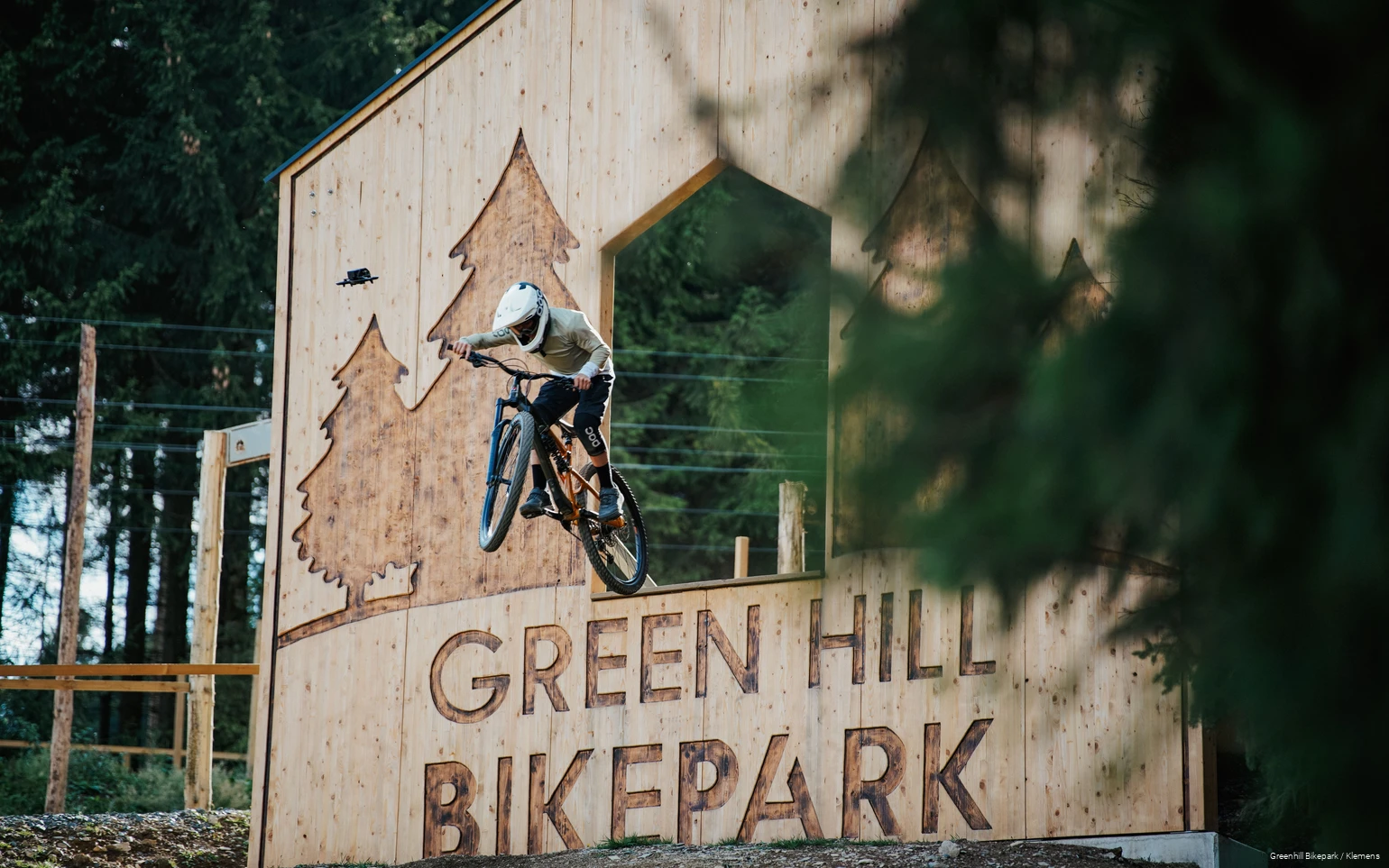 Ein Mountainbiker dropt in eine Strecke im Greenhill Bikepark im Sauerland.